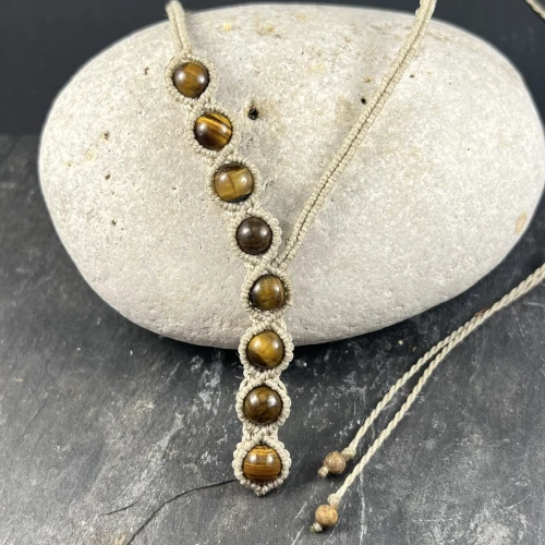 Gros plan perles naturelles œil de tigre collier asymétrique micro macramé unique